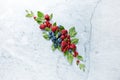 An Arrangement of fresh raspberries, blueberries, red currant and mint leaves on gray marble background.