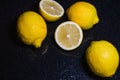 Arrangement of half lemons and whole organic lemons on a glittery black glass background Royalty Free Stock Photo
