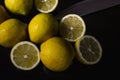 Arrangement of half lemons and whole organic lemons with a knife blade on a glittery black glass background Royalty Free Stock Photo