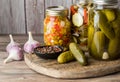 An arrangement of jars of various pickles on a wooden board with copy space.