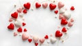 An arrangement of red, pink, and white heart-shaped objects covers a light background, forming a circular pattern Royalty Free Stock Photo