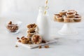 An arrangement of salted caramel pecan tartlets with a bottle of coconut milk.