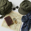 An arrangement of travel essentials on a white surface features an olive-green Royalty Free Stock Photo