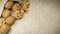 Arrangement of walnuts shells and walnut kernels in burlap sack on light wicker surface, with space for copy.
