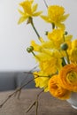Arrangement with yellow ranunculus and narcissus flowers on japanese eco holder kenzan in vase. Easter holiday concept.