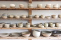 arranging handmade pottery on open kitchen shelves