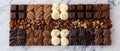 An array of assorted chocolate bars, including white, milk, and dark chocolate, accompanied by nuts on a dark surface Royalty Free Stock Photo