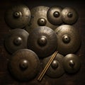 An array of bronze cymbals of varying sizes is arranged on a dark wooden surface. Royalty Free Stock Photo