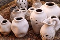 Array of ceramic vases positioned outdoors on a layer of soil