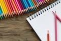 array of colored pencils fanned out beside a sketch pad Royalty Free Stock Photo