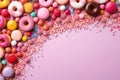 An array of colorful candies and doughnuts creatively scattered on a pink background.