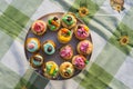 Array of colorful cupcakes displayed on a porcelain plate