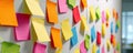An array of colorful and vibrant sticky notes are arranged on the wall. Royalty Free Stock Photo