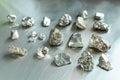 array of differentsized platinum nuggets on a steel surface Royalty Free Stock Photo