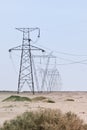 Array of electric pylons on a clear sky in desert