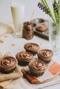 Array of freshly made cupcakes with decadent chocolate frosting.