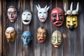 an array of funny masks on an old wooden wall