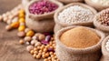 An array of grains and legumes, including millet, lentils, and beans, are arranged neatly in burlap sacks on a rustic Royalty Free Stock Photo