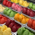 An array of ice cream flavors displayed in metal trays. Each tray contains scoops of Royalty Free Stock Photo