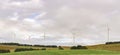 An array of large wind turbines moving to create kinetic energy for renewable energy supply Royalty Free Stock Photo