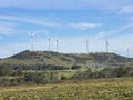 An array of large wind turbines moving to create kinetic energy for renewable energy supply Royalty Free Stock Photo