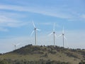 An array of large wind turbines moving to create kinetic energy for renewable energy supply Royalty Free Stock Photo