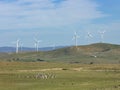 An array of large wind turbines moving to create kinetic energy for renewable energy supply Royalty Free Stock Photo