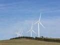 An array of large wind turbines moving to create kinetic energy for renewable energy supply Royalty Free Stock Photo