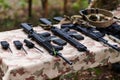 An array of military weapons, including rifles and pistols, is meticulously arranged on a table in a military base