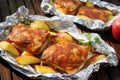 array of pork chops on aluminum foil, daubed with apple sauce