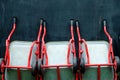 Red wheelbarrows against dark wall background