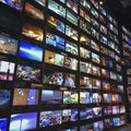 Wall of televisions displaying various channels in electronics store Royalty Free Stock Photo