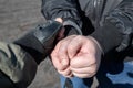 A police officer puts handcuffs on the hands of a bandit