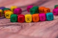 Word created with colored wooden cubes on desk.