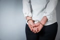 Arrested man handcuffed hands at the back on gray background