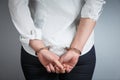 Arrested man handcuffed hands at the back isolated on gray background