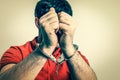 Arrested man in handcuffs hidden his face - retro style Royalty Free Stock Photo