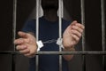 Arrested prisoner is holding bars in prison cell Royalty Free Stock Photo