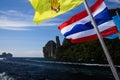 Arriving on tropical island Ko Phi Phi with ferry from Phuket - Close up of Thai flag waving from the boat with rocky coast line