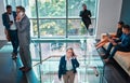 Arriving at work for the day. Shot of a mature businesswoman walking up the stairs while using a phone in a busy office Royalty Free Stock Photo