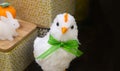 Arrogant looking white decrative easter chick with green bow with baskets and toy bunny in background - room for copy Royalty Free Stock Photo