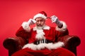 Proud, arrogant santa sitting on chair isolated on red background Royalty Free Stock Photo