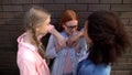 Arrogant students pushing with elbow female teen against wall school backyard