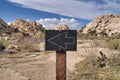 Arrow directional sign against rocks and blue sky at Joshua Tree National Park Royalty Free Stock Photo