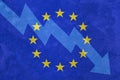 Arrow down on the background of the EU flag. The concept of economic recession, depression and crisis.