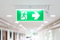 A Arrow light box sign of EMERGENCY FIRE EXIT is hung on the ceiling in hospital walkway, Idea for event fire or evacuation drills Royalty Free Stock Photo