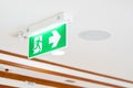 A Arrow light box sign of EMERGENCY FIRE EXIT is hung on the ceiling in hospital walkway, Idea for event fire or evacuation drills Royalty Free Stock Photo