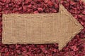 Arrow made of burlap lies on dried cranberries