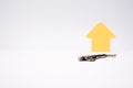 Arrow pointing up next to a key, symbolic image for incrising price and real estate market