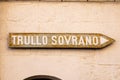 Arrow sign to the Trullo Sovrano. The Trullo Sovrano is two-story trullo house that is now a museum. Royalty Free Stock Photo